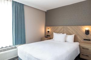Ένα ή περισσότερα κρεβάτια σε δωμάτιο στο Sandman Suites Vancouver on Davie