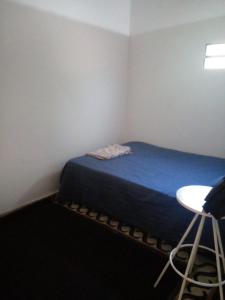 Cette petite chambre comprend un lit et une table. dans l'établissement mi Habitat, à Asuncion