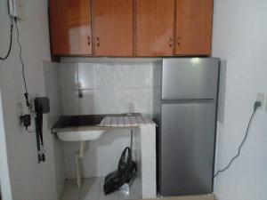 una pequeña cocina con nevera y fregadero en mi Habitat, en Asunción