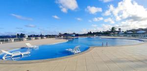 uma grande piscina com duas cadeiras e visor em Casa Térrea - Villa das Águas - Praia do Saco em Estância