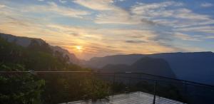 een balkon met uitzicht op de bergen bij zonsondergang bij Chez Nou ... in Salazie