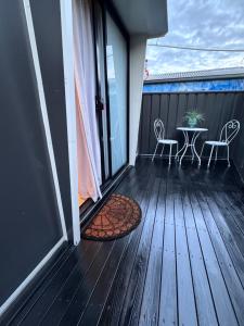a balcony with a table and chairs on a deck at Stylish tiny home in Melton west in Melton