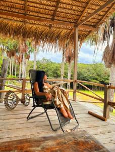 Ponta Poranga Jungle Lodge في ماناوس: امرأة تجلس على كرسي على سطح السفينة