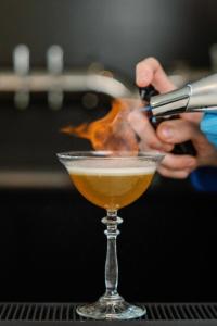 Eine Person bereitet einen Drink in einem Cocktailglas zu in der Unterkunft The Embers Hotel in Blowing Rock