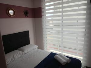 a bedroom with a bed and a large window at Apartamento cerca del Parque del Café in Montenegro