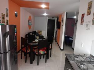 kuchnia i salon ze stołem i lodówką w obiekcie Apartamento cerca del Parque del Café w mieście Montenegro
