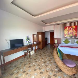 a bedroom with a bed and a desk and a television at Da Bungalows in Kata Beach