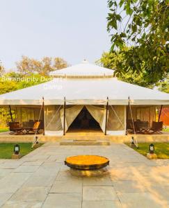 uma tenda grande com uma mesa em frente em Serendipity desert Camp in Thar Desert em Jaisalmer