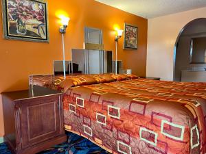 a large bed in a room with orange walls at Royal Inn - Neptune in Neptune City