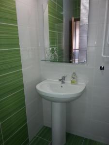 a white bathroom with a sink and a mirror at Prenociste Zan in Sarajevo