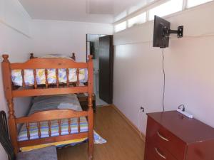 um pequeno quarto com um beliche e uma cómoda em Palm Hostal em Iquique