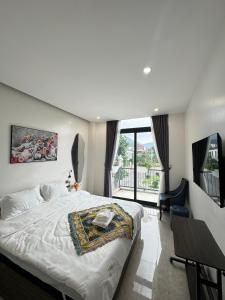 a bedroom with a large bed and a balcony at Liverpool House in Mộc Châu