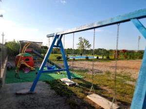 a playground with a swing set in a park at Casa cu Trandafiri Murighiol in Murighiol