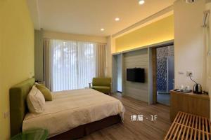 Habitación de hotel con cama y TV en The Riverview Retreats, en Wujie