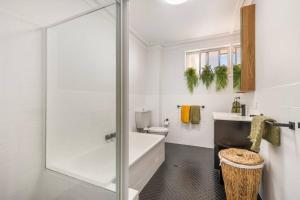 a bathroom with a shower and a tub and a toilet at 2 Bedroom Coastal getaway with ocean views! in Port Macquarie +12 photos