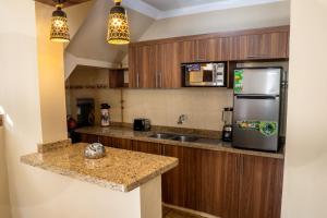 a kitchen with wooden cabinets and a stainless steel refrigerator at Apartamento tipo Dúplex en Sucre con garaje in Sucre