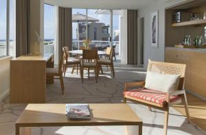 Sofitel Noosa Pacific Resort في نوسا هيدز: غرفة معيشة مع طاولة وكراسي