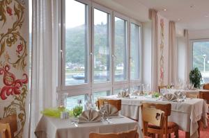 un comedor con mesas con manteles blancos en Weinhotel Landsknecht en Sankt Goar