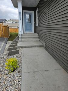 une porte d'entrée d'une maison avec une porte bleue dans l'établissement Home Away From Home, à Edmonton