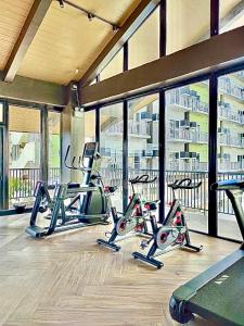 a group of treadmills in a gym with windows at 119 Amani Grand Mactan Resort in Mactan