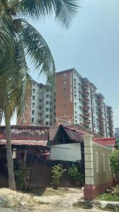 ポートディクソンにあるMilia Homestay PD Perdana Condoの高層建築の前にヤシの木がある建物 +3枚の写真