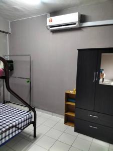 ポートディクソンにあるMilia Homestay PD Perdana Condoのベッド、ドレッサー、暖房が備わる客室です。
