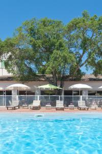 a swimming pool with lounge chairs and umbrellas at Résidence Domaine De Caranella in Porto-Vecchio +14 photos