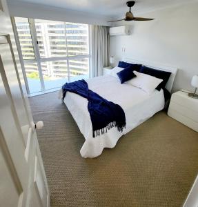 a bedroom with a large bed with blue pillows at 19th Avenue on the Beach in Gold Coast