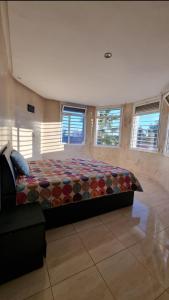 1 dormitorio con 1 cama grande en una habitación con ventanas en Belle maison de campagne en Kenitra