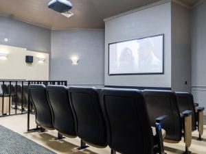 a room with a bunch of chairs and a screen at Luxury Disney Villa 5BR With Private Pool and Spa (4 Miles from Disney) in Orlando +26 photos
