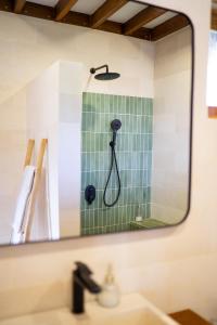 a mirror over a bathroom sink with a shower at Makai Medewi in Airsatang