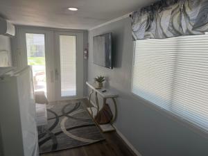 a living room with a window with blinds and a table at Gold Star in Plant City