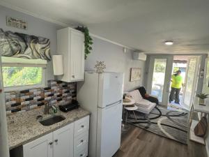 a kitchen with a refrigerator and a living room at Gold Star in Plant City