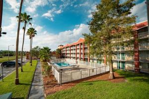 um edifício de apartamentos com piscina e palmeiras em Developer Inn Downtown Orlando, a Baymont by Wyndham em Orlando