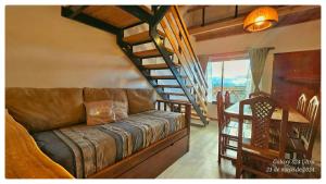 a living room with a couch and a spiral staircase at Ocho Cabañas Centro in San Carlos de Bariloche