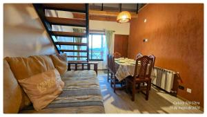 a living room with a couch and a dining room table at Ocho Cabañas Centro in San Carlos de Bariloche