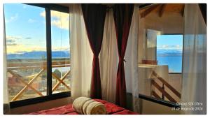 a bedroom with a window with a view of the ocean at Ocho Cabañas Centro in San Carlos de Bariloche