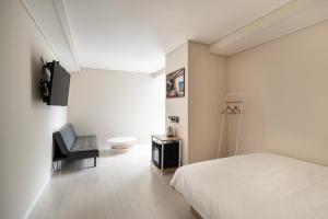 釜山的住宿－艾麗西亞精品酒店，白色卧室配有床和椅子