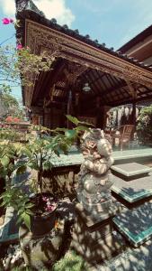 un jardín con una estatua frente a una casa en Wina Ubud B&B, en Ubud