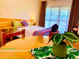 a bedroom with a bed and a table with a potted plant at Fundo Alma Andina in Jauja