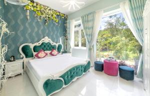 ダラットにあるHese Dalat Boutique Resortのベッドルーム(緑と白のベッド、窓付)