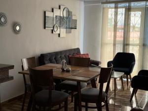 a dining room with a table and chairs and a couch at Alojamiento Villasofia in Armenia