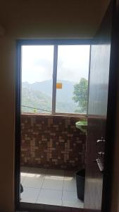 uma casa de banho com uma janela com vista para uma montanha em Banabas Homestay em Darjeeling