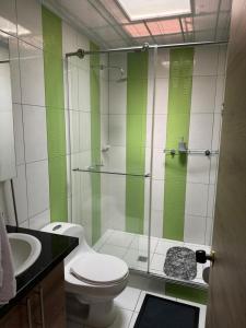 a bathroom with a toilet and a glass shower at Alojamiento Villasofia in Armenia