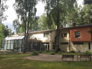 a building with two benches in front of it at Rēzijas in Ķegums