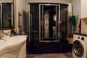 a bathroom with a shower and a white sink at ilim-mahabat in Bishkek