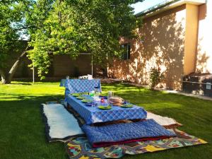 a blue table with plates of food sitting on the grass at ilim-mahabat in Bishkek