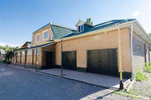 a brown brick house with a gate and a street at ilim-mahabat in Bishkek +8 photos