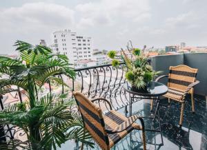 a balcony with chairs and a table with plants at V Hotel Vientiane in Vientiane