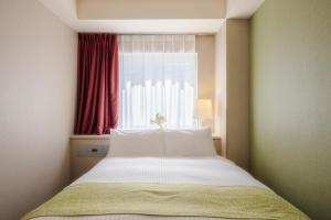 a bedroom with a large bed with a window at Shinjuku Washington Hotel Annex in Tokyo